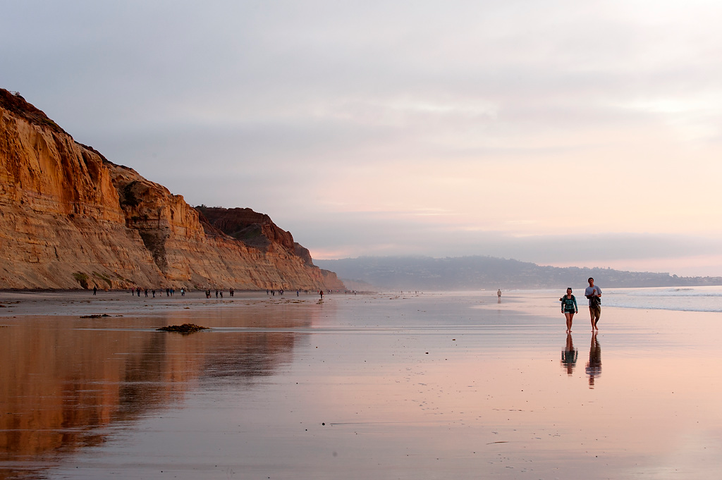People walking on beach near sunset